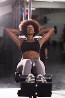 black woman doing sit ups at the gym photo