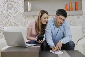 young couple working on laptop at home photo