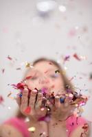 woman blowing confetti in the air photo