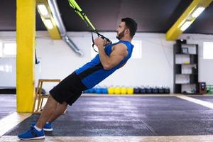 man working out pull ups with gymnastic rings photo