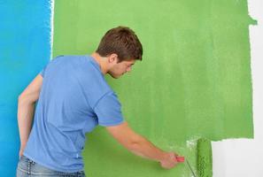 happy couple paint wall at new home photo