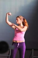 young woman with strong arms rising hands in air photo