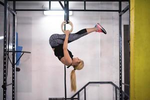 mujer trabajando en anillos de gimnasia foto