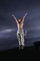young man dancing and jumping  on top of the building photo