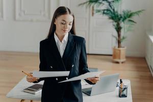 mujer de negocios exitosa que busca documentos durante la jornada laboral en la oficina foto