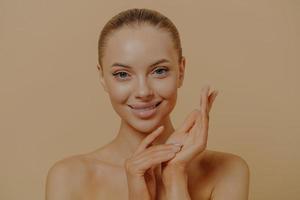 Beautiful woman touching smooth, baby-soft hands after spa procedures, isolated on pastel background photo