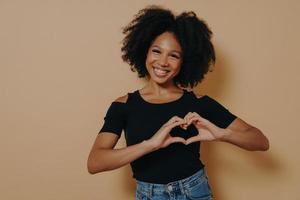 African american woman wearing casual clothes showing love gesture with heart shaped fingers photo