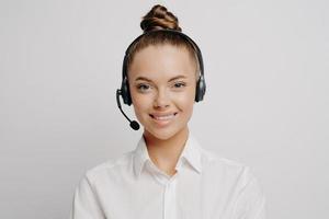 Female call center worker in white shirt smiling at camera photo