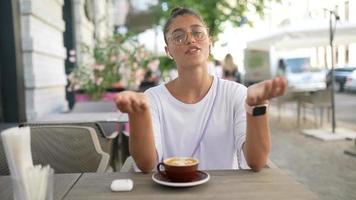 mooi vrouw zittend Bij buiten tafel cafe video