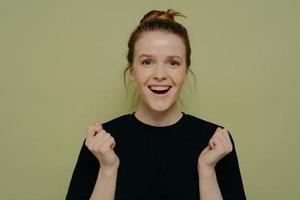 Excited teenage girl posing on green background photo