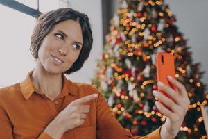 mujer italiana feliz haciendo videollamadas durante las vacaciones de invierno, hablando con la familia en línea foto