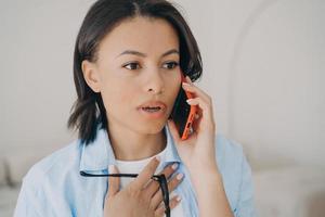 Anxious businesswoman has phone call. Online discussion at workplace and problem solving. photo