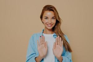 Joyful pretty model making stop sign using hands photo