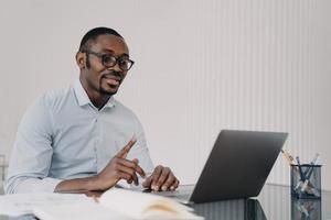 Kind boss, businessman in formal wear has online meeting in zoom. African man in front of camera. photo