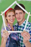 pareja feliz pintando una pared en su nuevo hogar foto