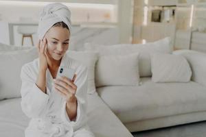 Woman beauty blogger creating video on smartphone for her vlog about daily skincare routine photo