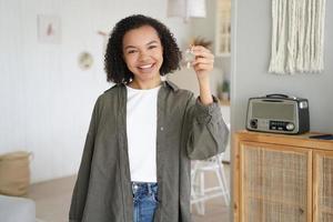 adolescente afroamericano recibe la llave del apartamento. Imagen conceptual de compra de hipotecas e inmuebles. foto