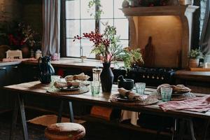 Indoor shot of served table with rolled napkins. Dinner time concept. Table setting decor. Interior of home kitchen. Rustic serving photo