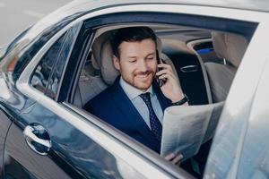 hombre de negocios elegante con ropa elegante y formal que viaja en un coche de lujo foto