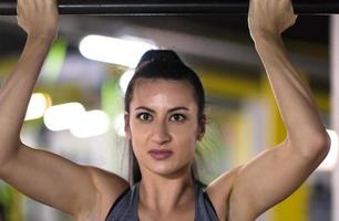 woman doing pull ups on the horizontal bar photo