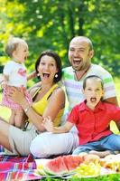 Feliz pareja joven con sus hijos divertirse en el parque foto