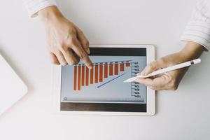 gente de negocios reunida para analizar y discutir y hacer una lluvia de ideas sobre los datos del gráfico del informe financiero en el trabajo en equipo del asesor financiero de la oficina y el concepto de contabilidad. foto