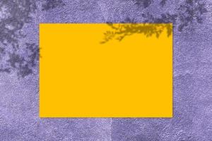 Empty yellow square poster mockup with light shadow on purple concrete wall background. photo