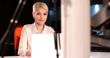 mujer que trabaja en la computadora portátil en la oficina nocturna foto