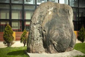 una gran piedra en el parque. un bloque adorna la calle. foto