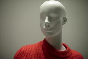 Mannequin in a red sweater. Shop window. Wool-bound clothing. photo