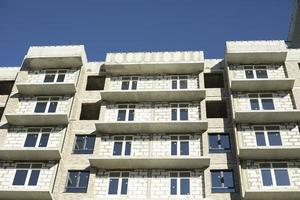 New building. Construction of an apartment building in Moscow. Residential house in sunlight. Inserted plastic windows in the house. photo