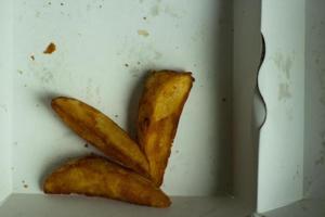 Fatty potatoes in a cardboard box. Fast food. photo