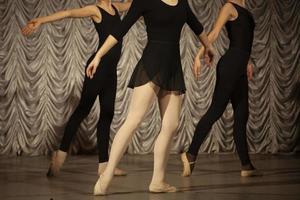 The girls rehearse the dance. Ballerinas in class. A girl in a black dress. photo