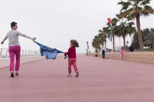 mother and cute little girl on the promenade by the sea photo