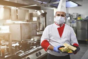 chef cook wearing face protective medical mask for protection from coronavirus photo