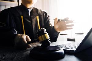 Business and lawyers discussing contract papers with brass scale on desk in office. Law, legal services, advice, justice and law concept picture with film grain effect photo