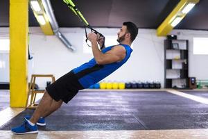 man working out pull ups with gymnastic rings photo