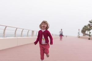 madre y niña linda en el paseo marítimo junto al mar foto