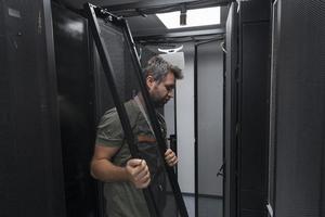 IT engineer working In the server room or data center The technician puts in a rack a new server of corporate business mainframe supercomputer or cryptocurrency mining farm. photo