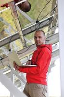 engineer using laptop at solar panels plant field photo