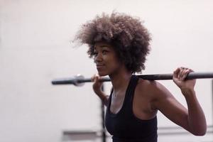 black woman lifting empty bar photo