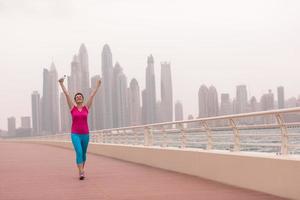 mujer joven celebrando una carrera de entrenamiento exitosa foto