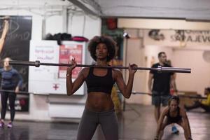 mujer negra levantando barra vacía foto