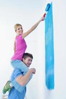 happy couple paint wall at new home photo