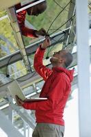 engineer using laptop at solar panels plant field photo