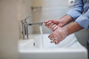 coronavirus male wahing hands in bathroom photo