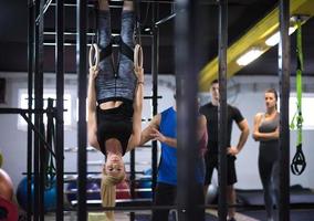 woman working out with personal trainer on gymnastic rings photo