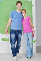 happy couple paint wall at new home photo