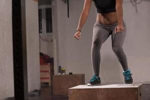 mujer negra está realizando saltos de caja en el gimnasio foto