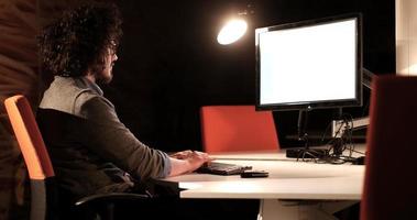 hombre trabajando en una computadora en una oficina oscura foto